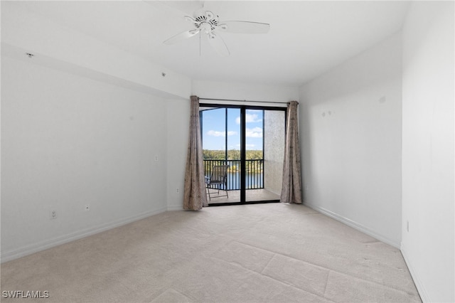 spare room with baseboards, light carpet, and ceiling fan