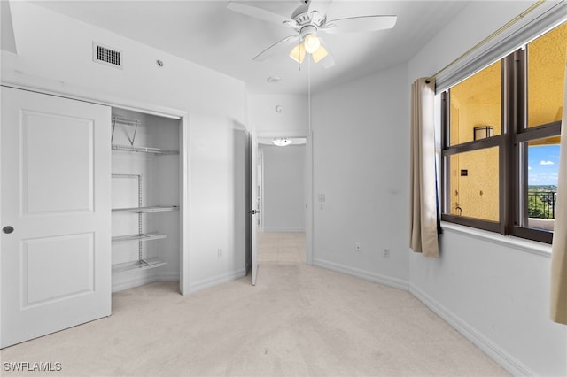 unfurnished bedroom featuring carpet, visible vents, baseboards, ceiling fan, and a closet