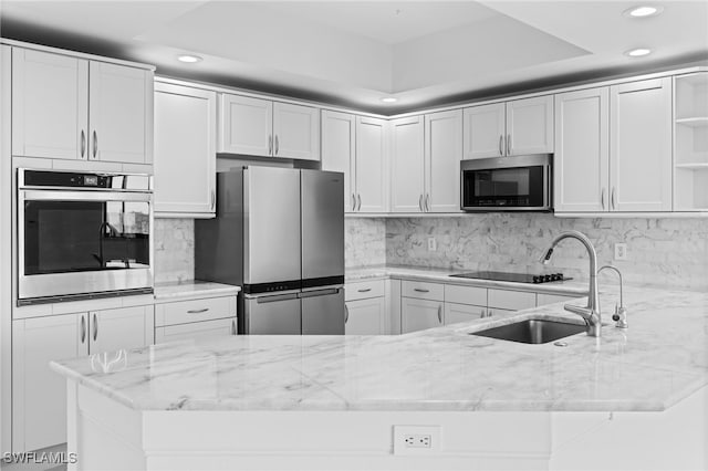 kitchen with open shelves, a sink, stainless steel appliances, decorative backsplash, and light stone countertops