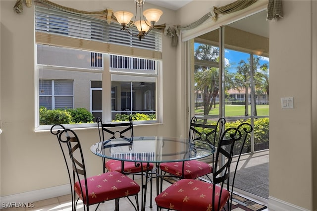 dining area featuring baseboards, a healthy amount of sunlight, and a notable chandelier