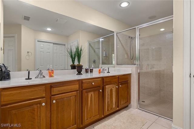 bathroom with a stall shower, double vanity, visible vents, and tile patterned floors