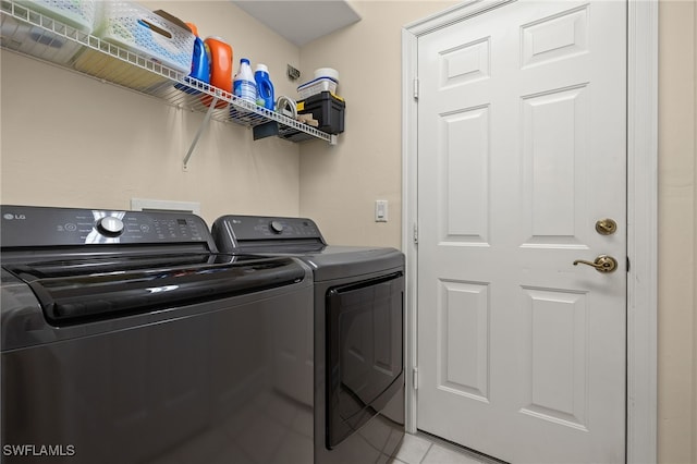 washroom with laundry area, light tile patterned floors, and washing machine and clothes dryer