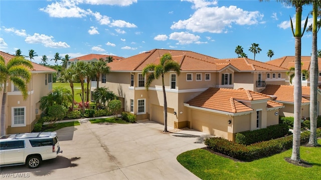 view of front facade with driveway, a tile roof, a residential view, and stucco siding