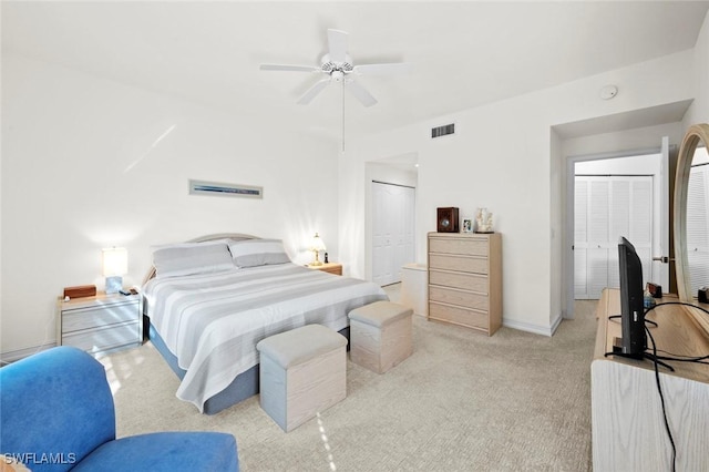 bedroom with visible vents, baseboards, ceiling fan, a closet, and light colored carpet