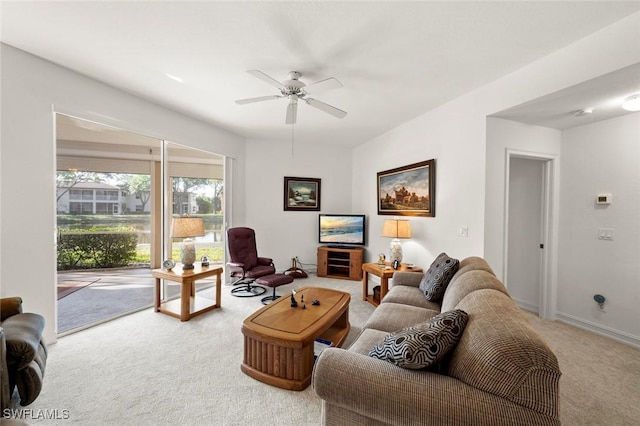 carpeted living room featuring baseboards and ceiling fan