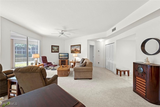 living room with light carpet, visible vents, and a ceiling fan