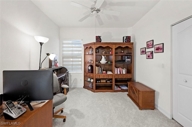 carpeted home office with a ceiling fan and baseboards