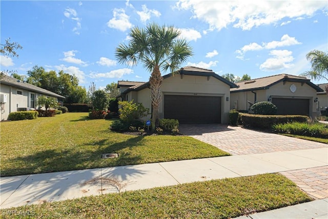 ranch-style home with a front lawn, decorative driveway, an attached garage, and stucco siding