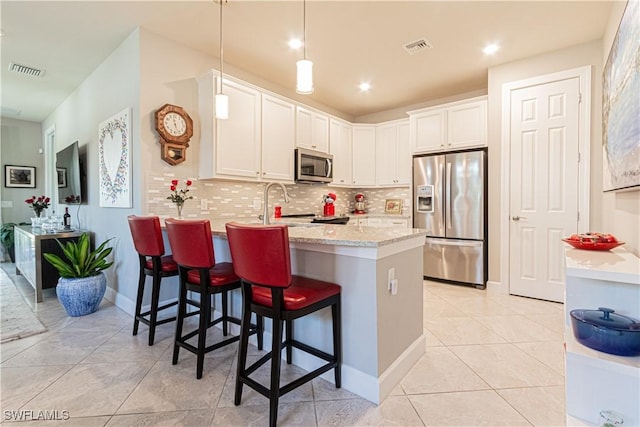 7658 Jacaranda Ln, Naples, FL 34114 - kitchen with visible vents, backsplash, white cabinetry, appliances with stainless steel finishes, and a peninsula