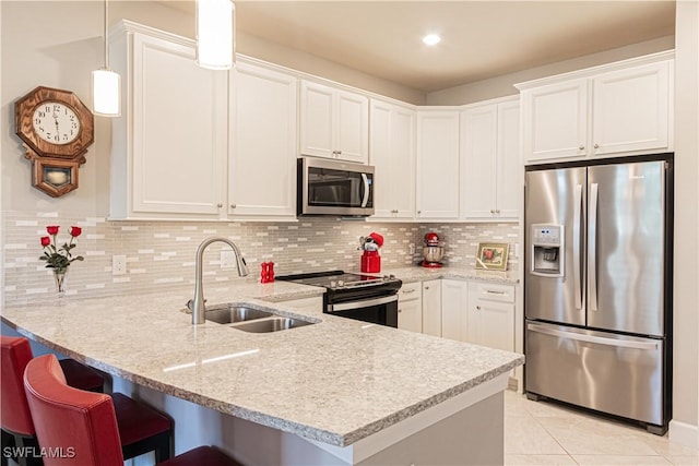 7658 Jacaranda Ln, Naples, FL 34114 - kitchen with a sink, appliances with stainless steel finishes, a peninsula, and white cabinets