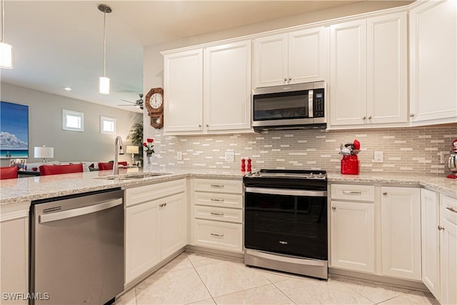 7658 Jacaranda Ln, Naples, FL 34114 - kitchen featuring a sink, ceiling fan, stainless steel appliances, pendant lighting, and tasteful backsplash