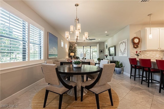 7658 Jacaranda Ln, Naples, FL 34114 - dining space featuring plenty of natural light, ceiling fan with notable chandelier, visible vents, and baseboards