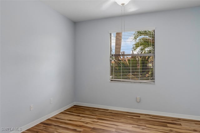 unfurnished room featuring baseboards and wood finished floors