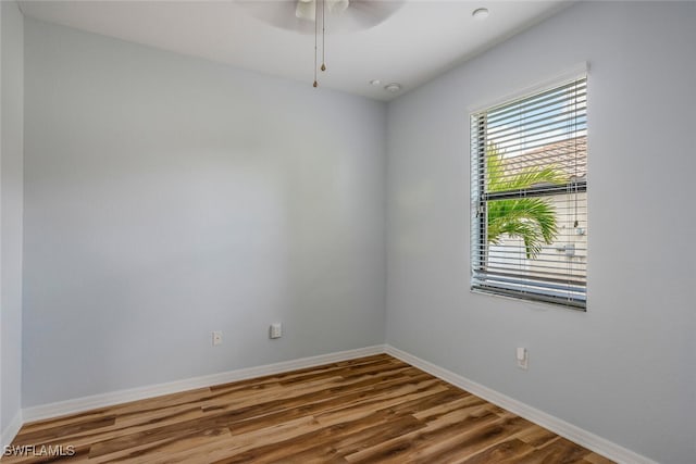 unfurnished room with a ceiling fan, baseboards, and wood finished floors