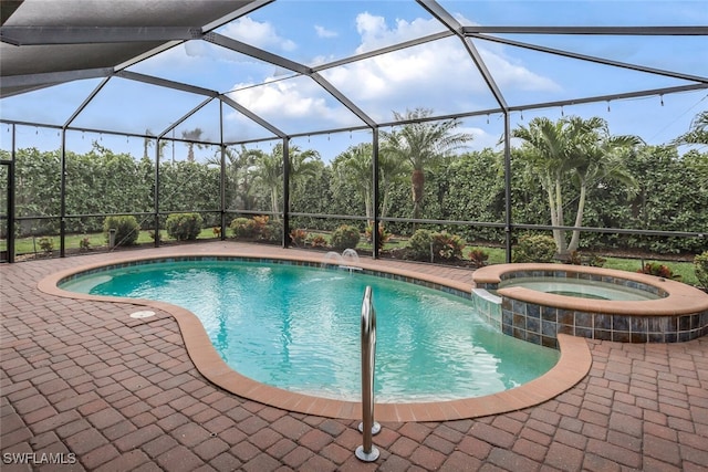 view of pool with a patio area, a pool with connected hot tub, and glass enclosure