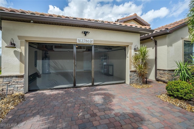 garage featuring decorative driveway and water heater