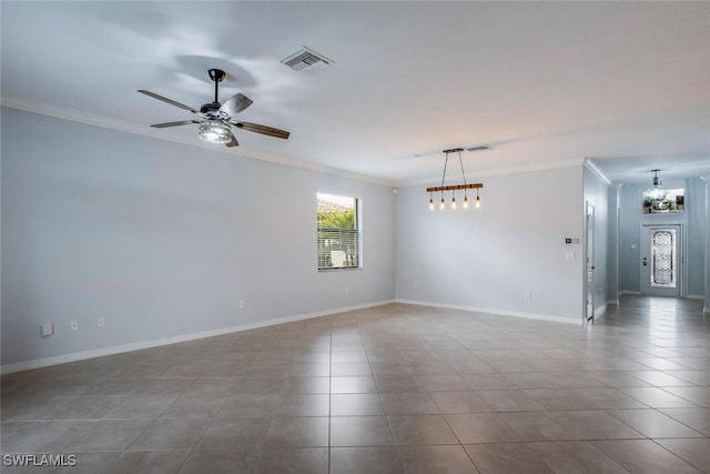 spare room featuring ceiling fan with notable chandelier, visible vents, baseboards, tile patterned floors, and crown molding