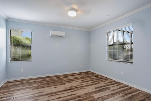 spare room with ornamental molding, a wall mounted AC, wood finished floors, and a healthy amount of sunlight