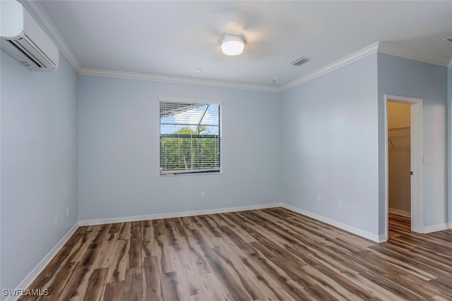 unfurnished bedroom with wood finished floors, visible vents, crown molding, and a wall mounted AC