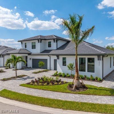 view of front of home with a garage and decorative driveway