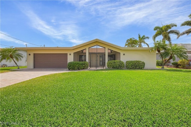 view of front of home with a garage, a front lawn, decorative driveway, and stucco siding