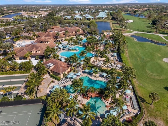 drone / aerial view with view of golf course and a water view