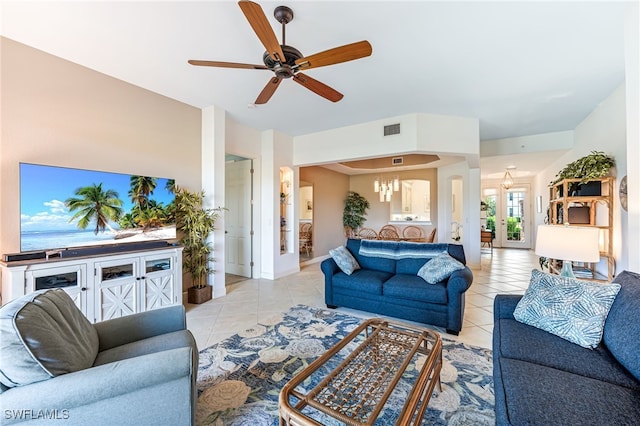 living area with ceiling fan with notable chandelier, french doors, light tile patterned flooring, and visible vents