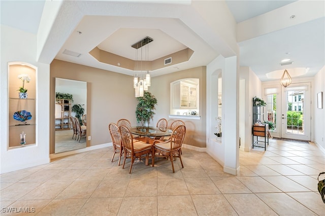 dining space with light tile patterned floors, a tray ceiling, and visible vents