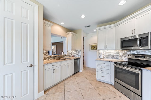 kitchen featuring decorative backsplash, light tile patterned flooring, stainless steel appliances, a sink, and recessed lighting