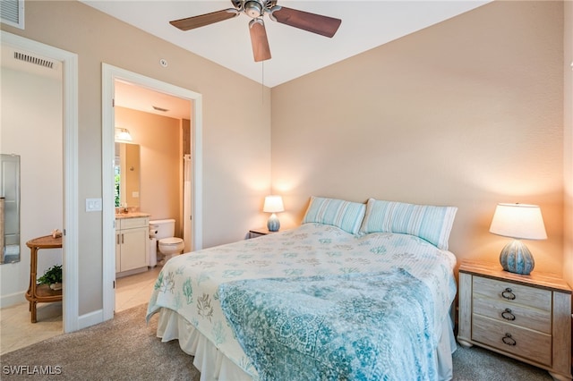 bedroom featuring light colored carpet, visible vents, ensuite bath, and baseboards