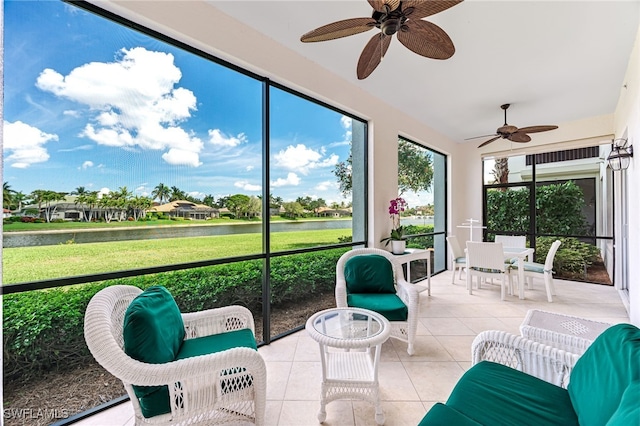 sunroom featuring a water view and a ceiling fan