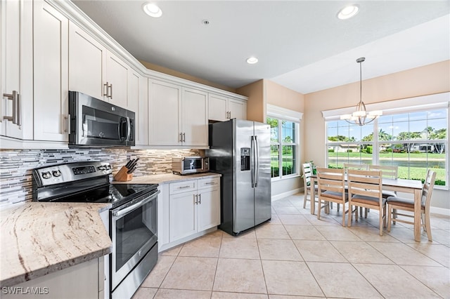 kitchen featuring light tile patterned floors, stainless steel appliances, white cabinets, backsplash, and an inviting chandelier