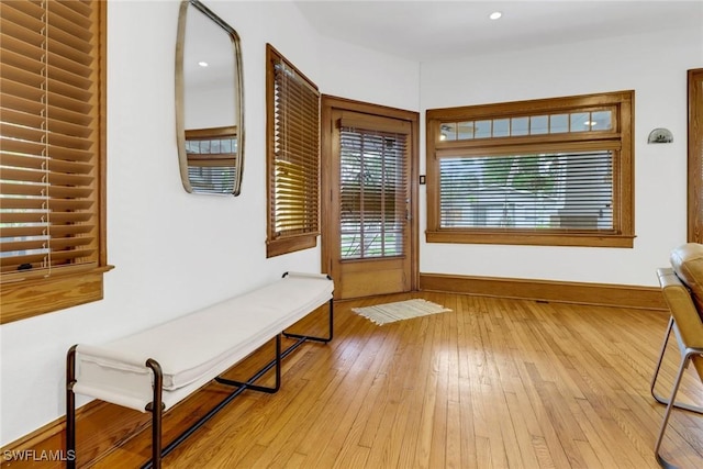 doorway to outside with light wood-style floors and baseboards