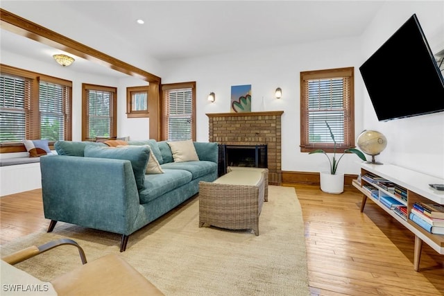 living room featuring baseboards, light wood-type flooring, a fireplace, and recessed lighting