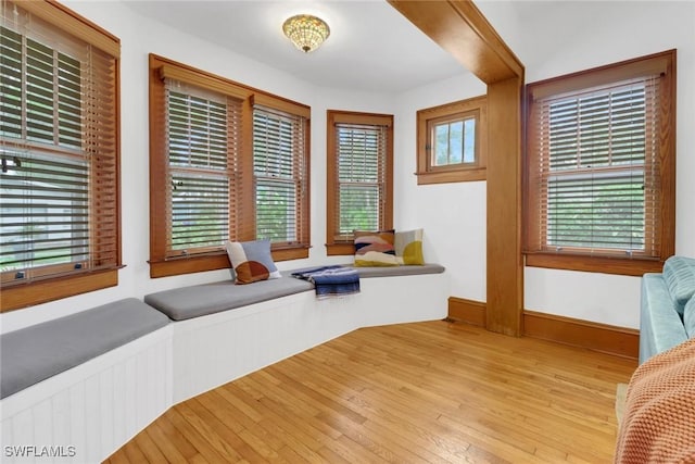 sitting room with a healthy amount of sunlight, baseboards, and wood finished floors