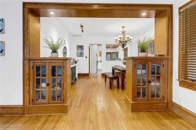 interior space with a chandelier, recessed lighting, baseboards, and light wood finished floors