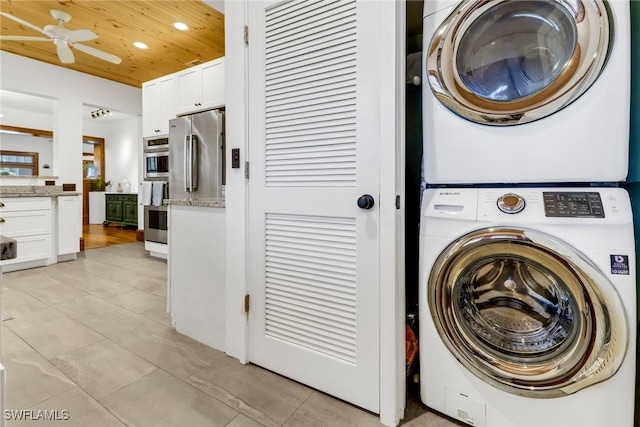 laundry area featuring laundry area, light tile patterned floors, stacked washer / dryer, wood ceiling, and recessed lighting