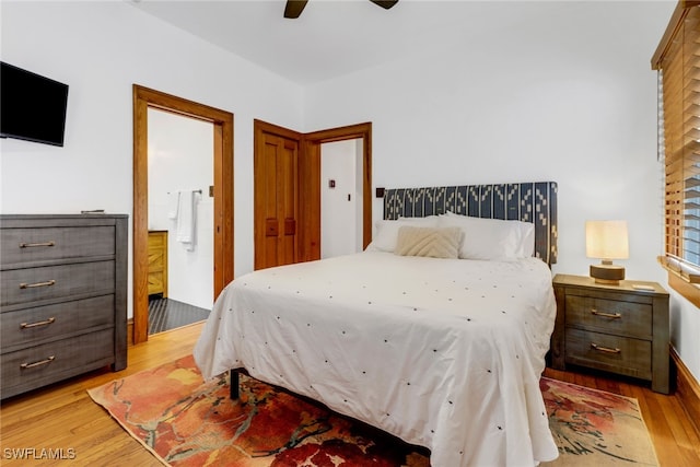 bedroom with ceiling fan, light wood-type flooring, and connected bathroom