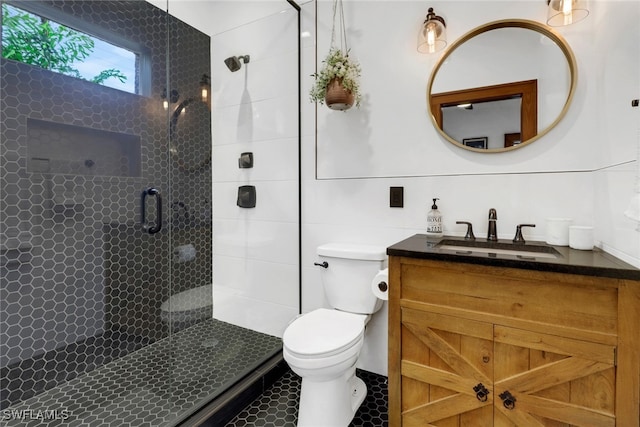 full bathroom featuring a stall shower, tile walls, vanity, and toilet