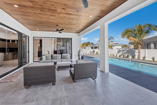 view of patio / terrace featuring a fenced in pool, a fenced backyard, an outdoor living space, and a ceiling fan