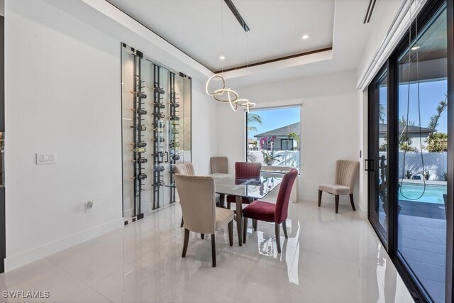 dining room with light tile patterned floors, baseboards, a raised ceiling, and recessed lighting