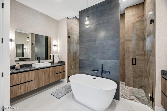 bathroom featuring a stall shower, a freestanding tub, tile walls, and vanity