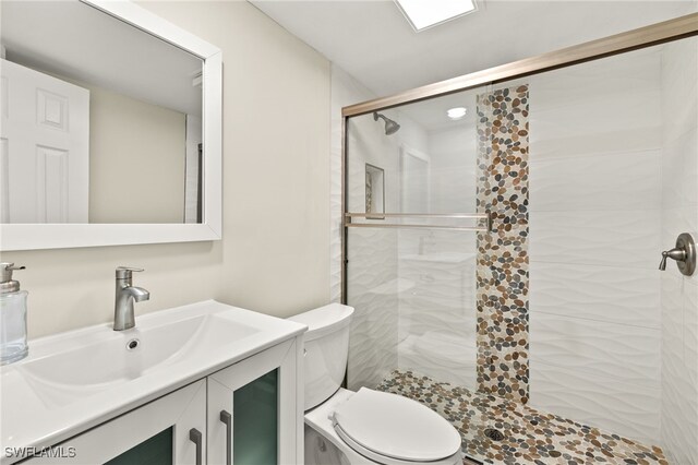 full bathroom with a shower stall, toilet, and vanity