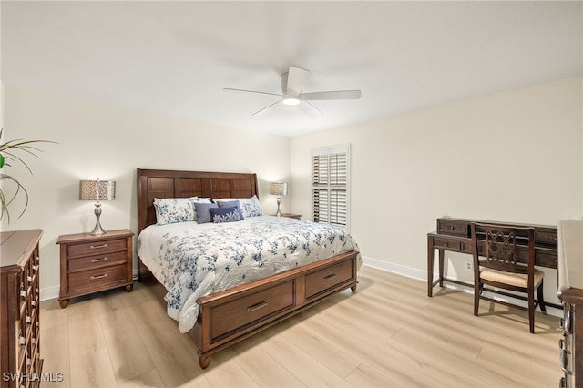 bedroom featuring baseboards, light wood-style floors, and a ceiling fan