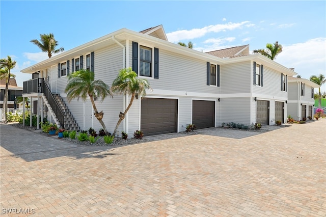 view of front of home featuring stairway, driveway, and a garage