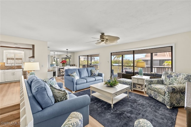 living area with ceiling fan and wood finished floors