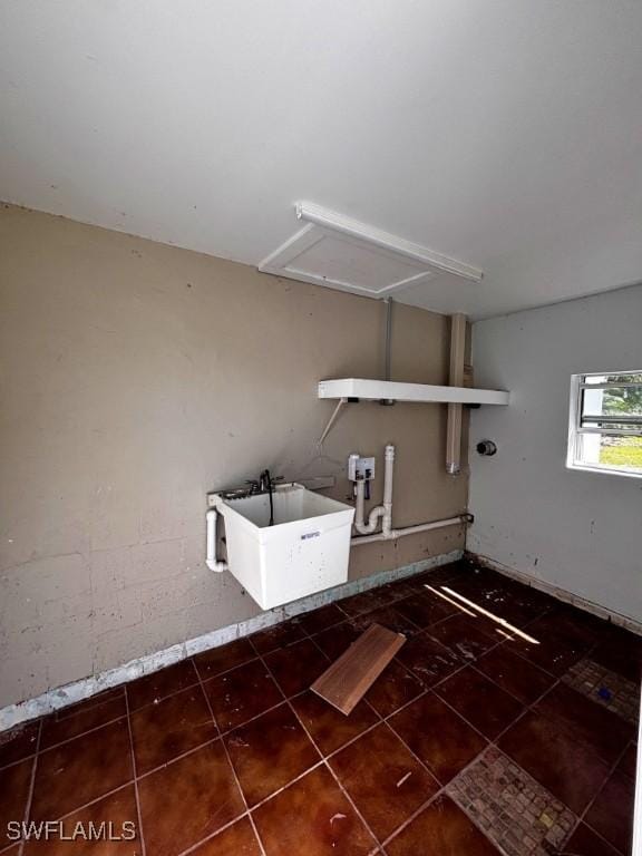 clothes washing area with a sink and tile patterned floors