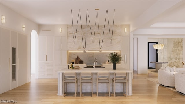 bar featuring light wood-style floors and a sink