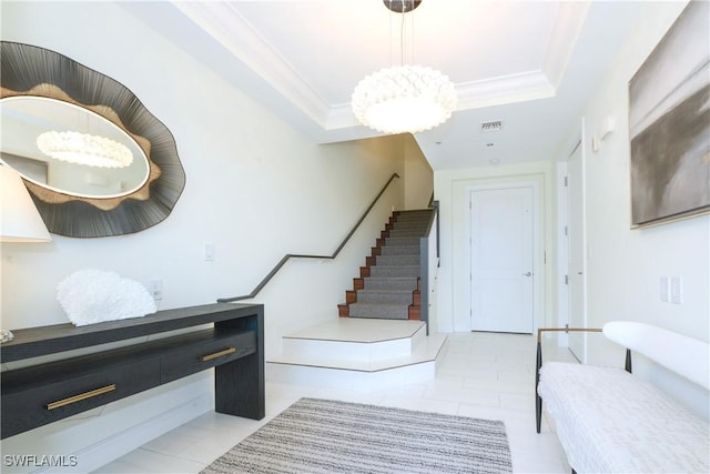 stairs with a tray ceiling, tile patterned floors, visible vents, and crown molding