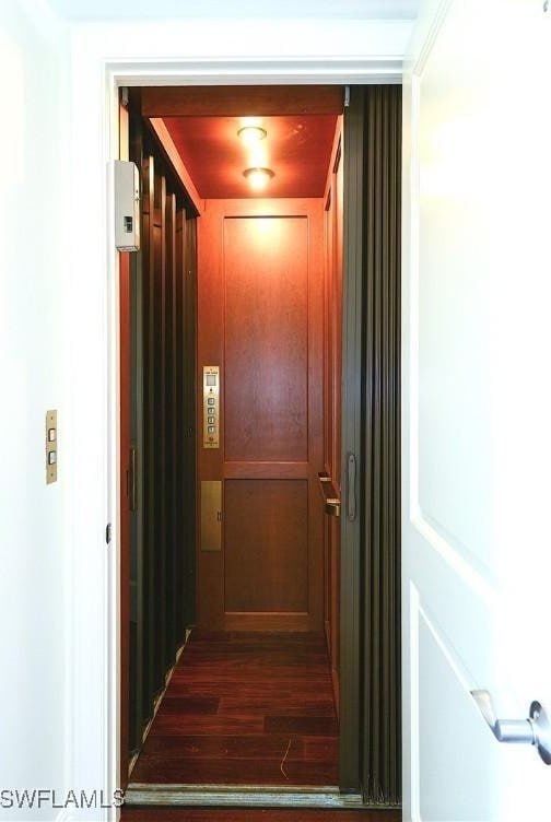 hall with elevator and dark wood finished floors